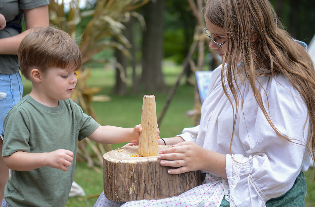 Jenna Peavler helps Amir Patlan grind corn into flour